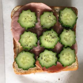 再放上两片火腿片，铺上黄瓜片，撒适量黑胡椒碎