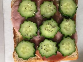 再放上两片火腿片，铺上黄瓜片，撒适量黑胡椒碎