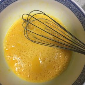 蛋清和蛋黄分开，蛋黄里加入20g幼砂糖，用手动打蛋器打匀，接着倒入牛奶，继续搅打均匀