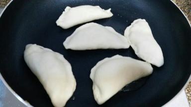 平底锅内放入少量油，韭菜盒子放进去，小火慢慢煎