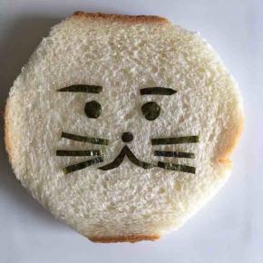 用一片海苔片剪出小狮子的眼睛、眉毛、鼻子、嘴巴和胡须，稍微沾一点点纯净水就可以粘在一片吐司片上