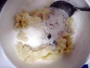 从微波炉取出打熟的土豆，加入牛奶、盐和黑胡椒；