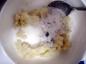 从微波炉取出打熟的土豆，加入牛奶、盐和黑胡椒；