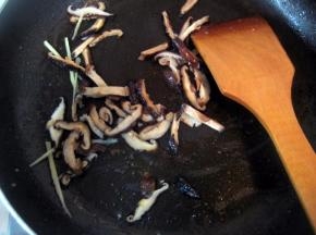 利用锅中的底油，将香菇和一半的姜丝爆出香味