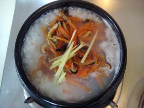 等米粒开花时，加入瘦肉丝、香菇、胡萝卜、姜丝。