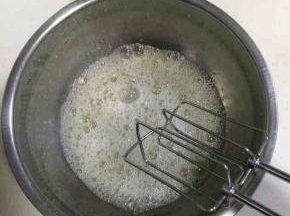 用电动打蛋器低速把蛋白打至粗泡，加入1/3细砂糖后继续搅打。（加入蛋白部分的细砂糖合计是40克）