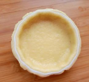 取适量面团擀成面片放入模具压实，用擀面杖把边上多余的面皮去掉。饼底用叉子扎眼。