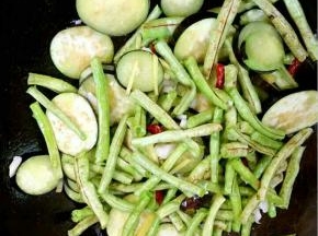 放入处理好的茄子和豆角翻炒均匀！
