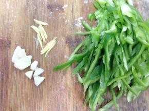 青椒洗净去蒂，切成丝，蒜切片，姜切丝。