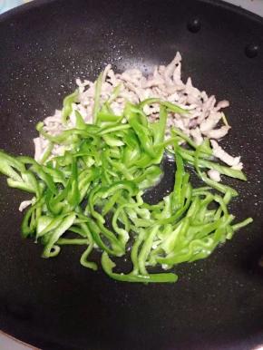 放入青椒丝，炒至断生。