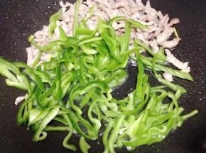 放入青椒丝，炒至断生。