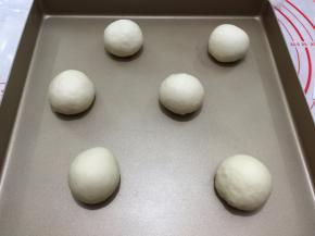 再将每个小面团都整成圆形，依次放入烤盘内