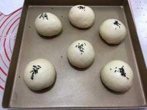 将面团发酵至两倍大小用喷壶在面包表面喷少许水
撒上黑芝麻