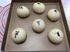 将面团发酵至两倍大小用喷壶在面包表面喷少许水
撒上黑芝麻