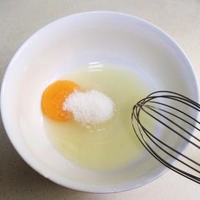 在鸡蛋内加入细砂糖，用手动打蛋器搅拌均匀。