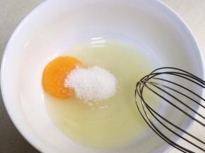 在鸡蛋内加入细砂糖，用手动打蛋器搅拌均匀。