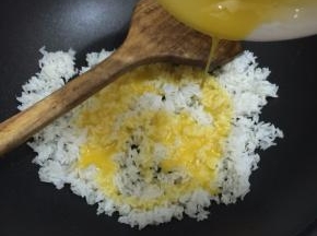 炒锅加油烧热，加入白米饭炒散