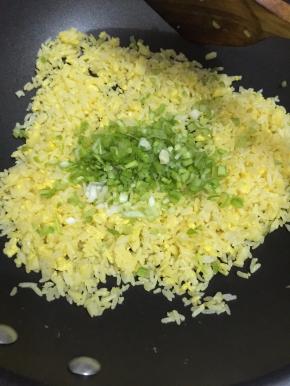 这是要把火调到中火，迅速翻炒米粉和蛋黄，使蛋黄能均匀的裹在每颗米粒中，才能使每颗米粒都是金黄色的