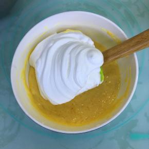 取三分之一的蛋白霜到蛋黄糊里，用刮刀翻拌均匀。