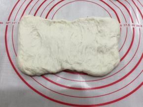 分割成2个等份的面团，取一份面团，拍成长方片
保留面团中的气体，把非常大的气泡拍出