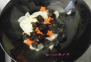 倒入山药片、木耳和胡萝卜花片，翻炒；