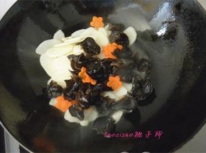 倒入山药片、木耳和胡萝卜花片，翻炒；