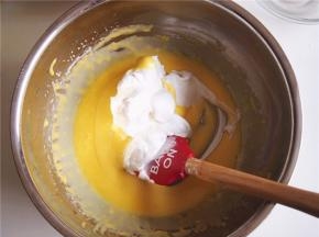 将三分之一的蛋白霜加入蛋黄糊中，切拌均匀