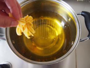 油锅烧至6成热，倒提着菊花坯子放入油锅中炸制