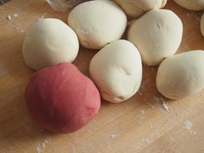 发酵好的面团分成24份，其中4份加入红曲米粉，揉均匀成为红曲面团