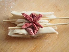 两根竹签在面团两侧压一下，同时向中心挤一下