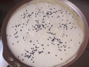 平底锅加入适量油加热，倒入一勺面糊，撒上适量黑芝麻