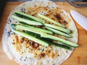 在没有鸡蛋的那面抹上豆瓣酱，裹上黄瓜条或者其他自己喜欢吃的青菜之类，卷起即可