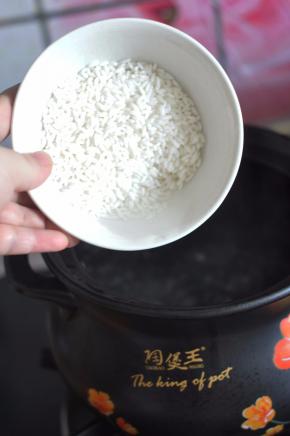 砂锅里加入水，水开后倒入大米。