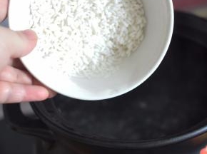 砂锅里加入水，水开后倒入大米。