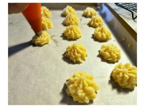 预热烤箱180上下火。用8齿中号花嘴。裱花袋放置到高的杯子，中间刮入面糊。裱花袋排出空气。高1cm的地方挤出曲奇花。