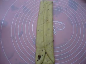 将松驰好的面团再次排气，擀成椭圆形，两边向内对折，擀薄；