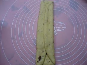 将松驰好的面团再次排气，擀成椭圆形，两边向内对折，擀薄；