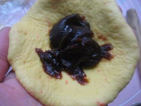 取松驰好的60克面团擀成圆形，翻面后放上适量红豆馅，包好捏紧收口；