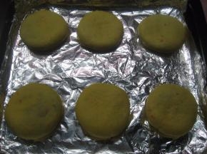 包好的面团压扁，收口朝下放入烤盘中。