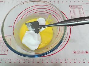 10. 将1/2的蛋白霜倒入蛋黄糊中，用手动打蛋器从盆底由下向上快速翻拌