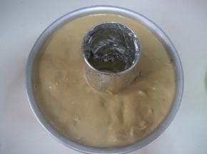 拌匀的蛋糕糊倒入蛋糕模中，抹平蛋糕糊表面。拿起模子在案板上轻磕几下，震出面糊中的
      气泡；