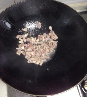 锅里倒入适量的油，把肉丁加入翻炒