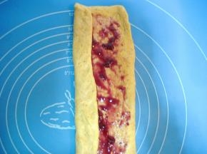 在面片上抹上适量蓝莓酱（蓝莓酱不要抹太多，要不卷起和烤制作过程中会漏馅。或者在蓝莓酱中加少许淀粉),面片头尾不要抹果酱，将面片两边向中间对折；