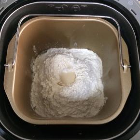 除黄油以外的面包材料都放入面包机内（先液体后粉类的顺序），在面粉中间挖个洞，把酵母粉倒进去，启动和面程序。
