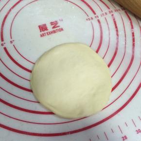 待面团松弛完毕，取一份面团擀成圆面皮状。