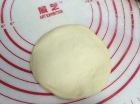 待面团松弛完毕，取一份面团擀成圆面皮状。