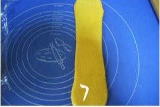 取一松驰完的面团，收口朝上按扁，擀长，压薄底边；