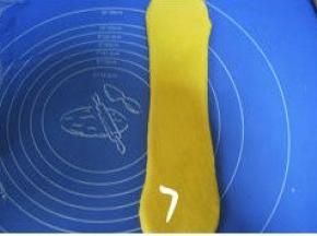 取一松驰完的面团，收口朝上按扁，擀长，压薄底边；