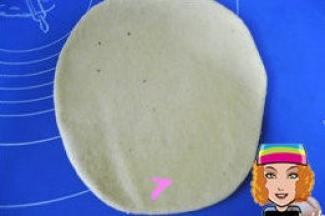 用擀面杖把面团向四周擀开；