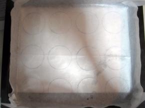 在白纸画出大小相等的圆圈（我用的是口维可果酱瓶盖，画了12个圆圈），将画好图案的白纸放在烤盘上，再将油纸铺在上面。如果嫌麻烦，也可省略在纸上画圈，直接将油纸铺在烤箱盘上，最后把面糊挤在油纸上即可。